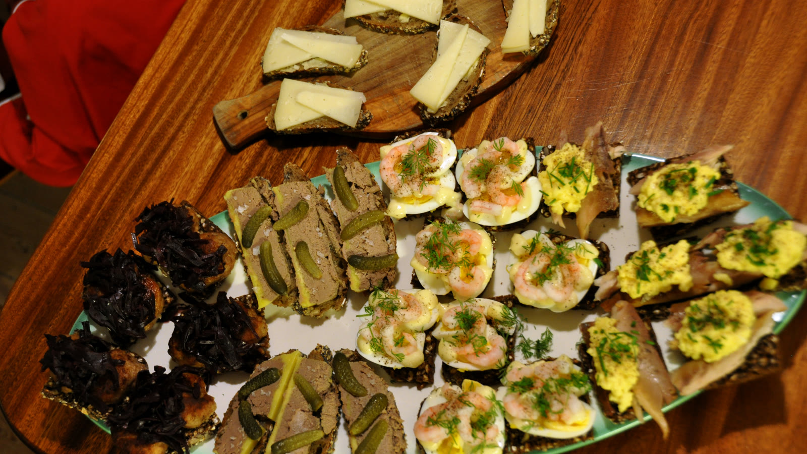 Fad med smørrebrød til det kolde bord: makrel med røræg, æg med rejer, leverpostej med agurk, frikadeller med rødkål og ost på rugbrød